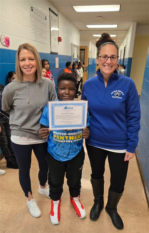 Festo Byiringiro, Pfeiffer-Burliegh's Stairclimber for December, poses with his award plaque.